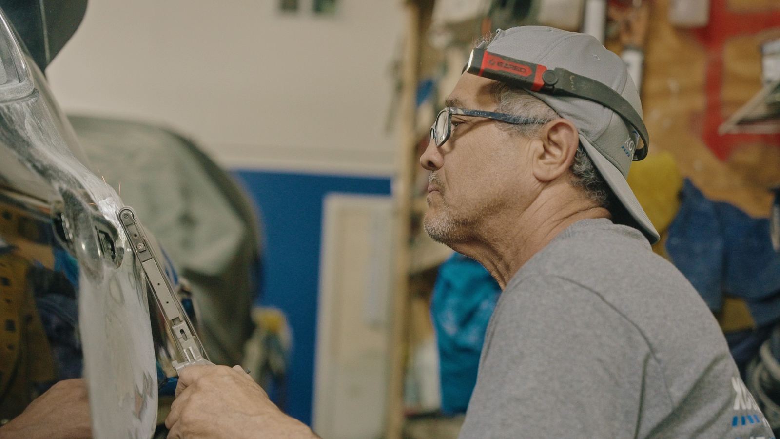 Body technician shaping a damaged panel